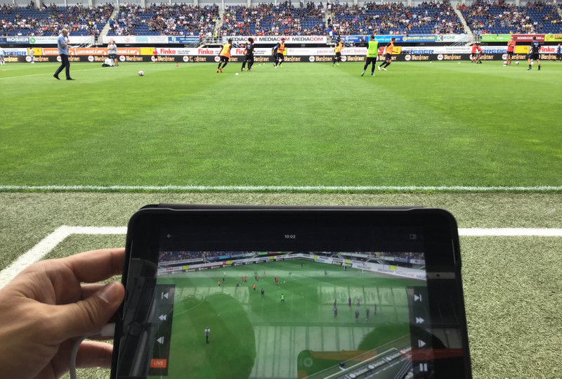 Um gerente assiste o vídeo ao vivo na área técnica durante um jogo de futebol