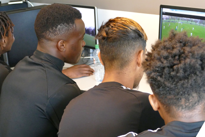 Time de futebol assistindo a replays em um laptop